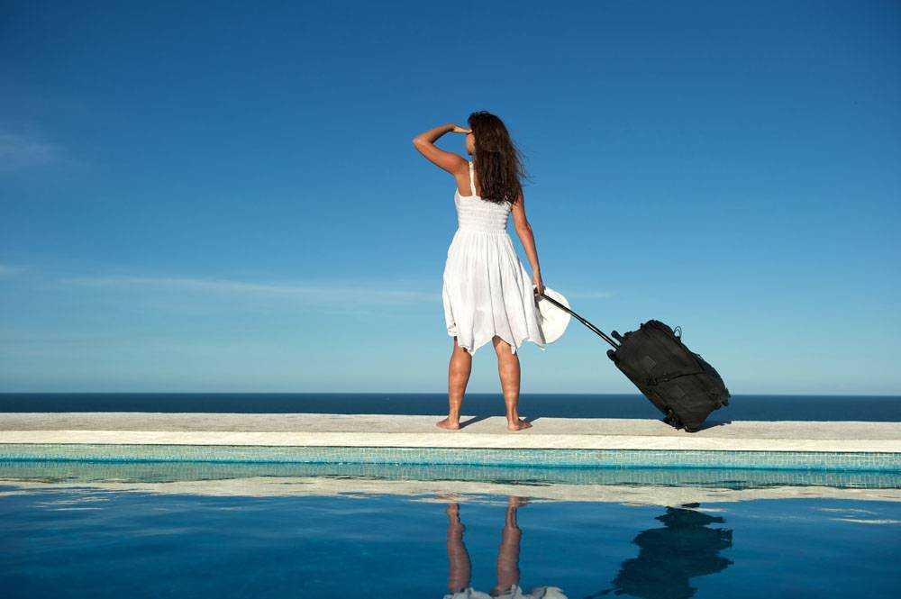 Выгодно ли в мае ходить в отпуск. Девушка с чемоданом на море. Отпуск девушка с чемоданом. Девушка с чемоданом на пляже. Девушка отпуск море чемодан.
